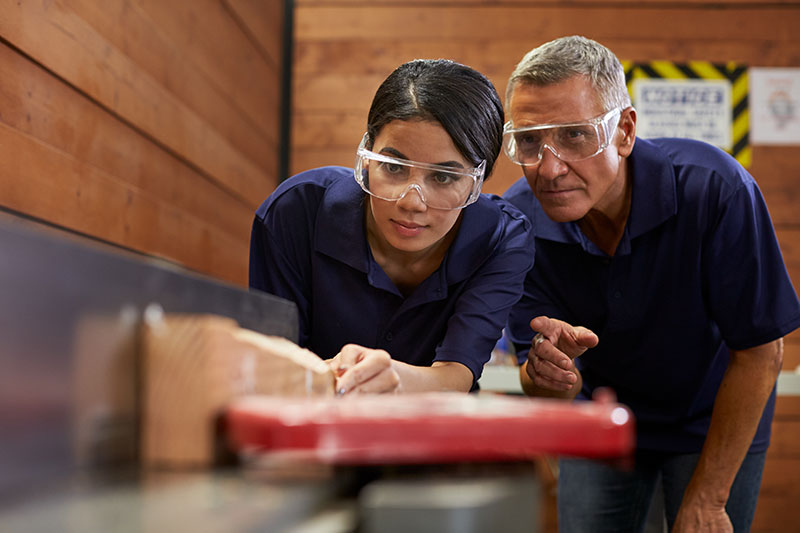 two people working with a table saw